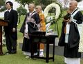Hiro eulogizes as several monks look on.