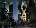 Daphne and Linderman speak outside in front of a statue of a helix.